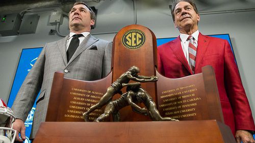 Two men, but only one trophy: Georgia's Kirby Smart (left) and Alabama's Nick Saban strike a pose behind the SEC Championship hardware Friday.