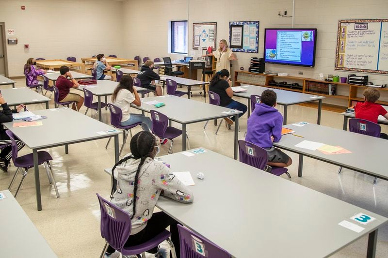 08/20/2020 - Cartersville, Georgia - Cartersville Middle School Technology teacher Michelle Cottingham (front of classroom) welcomes a group of socially distanced seventh graders to her classroom during their first day of hybrid classes at Cartersville Middle School in Cartersville, Thursday, August 20, 2020.  (ALYSSA POINTER / ALYSSA.POINTER@AJC.COM)