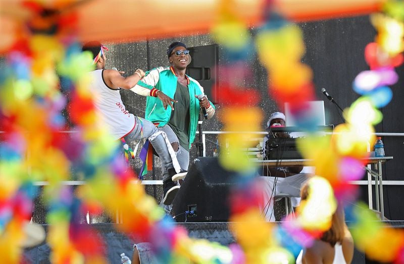 In this file photo, rapper Coleque (right) and his partner Muze are framed in pride flowers while performing during the 2016 Atlanta Black Gay Pride weekend at Piedmont Park. Curtis Compton /ccompton@ajc.com