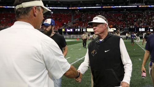 Colquitt County head coach Rush Propst (right) shakes the hand of McEachern head coach Kyle Hockman after their game at the Corky Kell Classic Saturday, August 18, 2018, at Mercedes-Benz Stadium in Atlanta. Colquitt County won, 41-7.