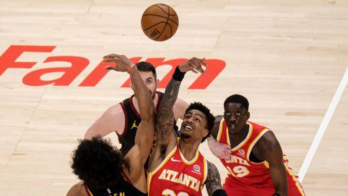 Atlanta Hawks forward John Collins (20) goes up against Cleveland Cavaliers center Jarrett Allen (31) for the opening tipoff Sunday, March 14, 2021, at State Farm Arena in Atlanta. (Ben Gray/AP)