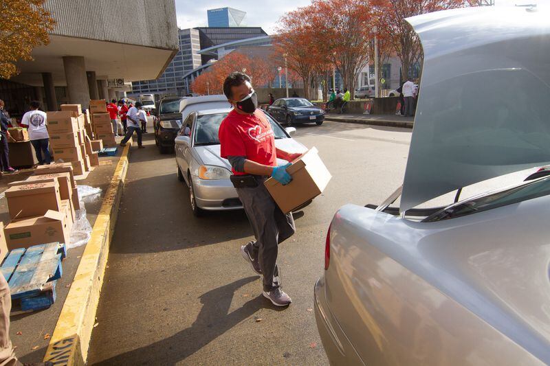 A volunteer loads boxes of food into cars outside the Georgia World Congress Center during the annual Hosea Williams Thanksgiving Dinner on Thursday, November 26, 2020. Because of the pandemic, this year's dinner was to-go. This marked the 50th year the nonprofit Hosea Helps has been aiding those in need with the event. (Photo: Steve Schaefer for The Atlanta Journal-Constitution)
