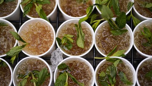 Cups of Mint Julep are prepared for a vender before the 149th running of the Kentucky Derby horse race at Churchill Downs Saturday, May 6, 2023, in Louisville, Ky. (AP Photo/Brynn Anderson)