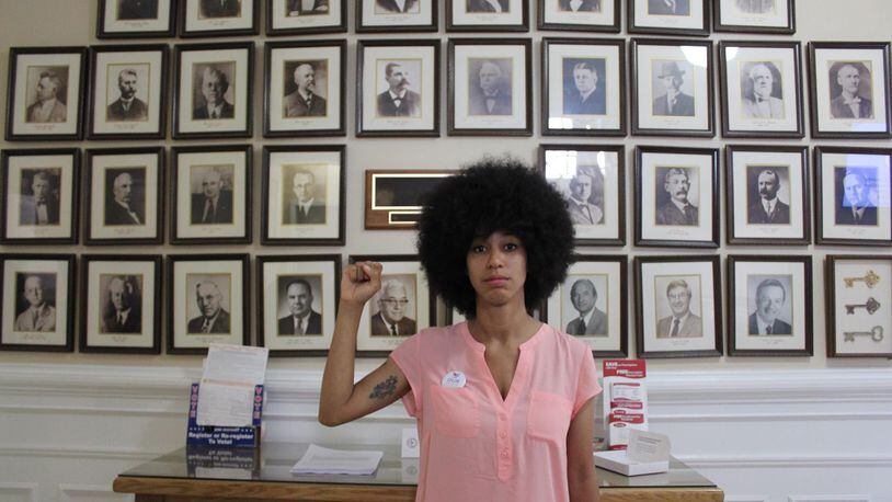 Mariah Parker, a 26-year-old University of Georgia doctoral student and newly elected Athens-Clarke County commissioner, stands before portraits of former elected officials inside Athens City Hall.