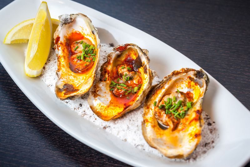  The grilled oysters with lemon butter and smoked paprika at Simon's Restaurant in Midtown. PHOTO CREDIT: Christopher Watkins