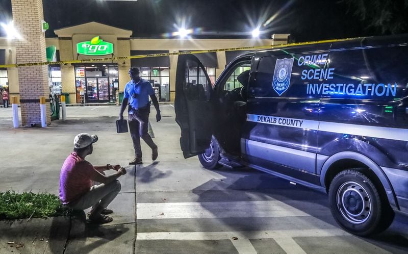 DeKalb County police investigators collect evidence and speak with witnesses outside a BP gas station on Flat Shoals Road, where a deadly shooting unfolded early Wednesday morning.