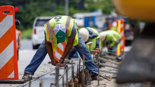 Construction workers work along Church street in Decatur on Monday, July 25, 2022. The projected high is 90 degrees. (Arvin Temkar / arvin.temkar@ajc.com)