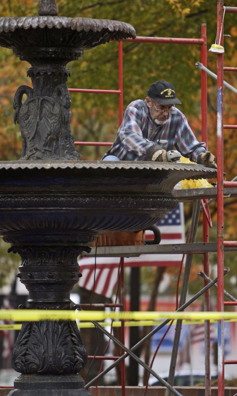 Nov. 10, 2009: Contractor Dan Spinney removes the damaged primer from the Marietta Square fountain. The fountain is being "re-refurbished." It had rained the day after the paint job the previous year, which damaged the primer.