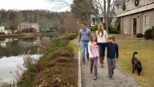 Josh and Julie Laskowski walk around the lake in their subdivision with their dog and children.