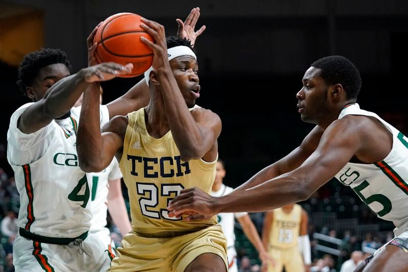 Georgia Tech forward Jordan Meka looks for an opening past Miami guards Bensley Joseph (4) and Wooga Poplar (55) during the first half Wednesday night in Coral Gables, Florida. (AP Photo/Wilfredo Lee)