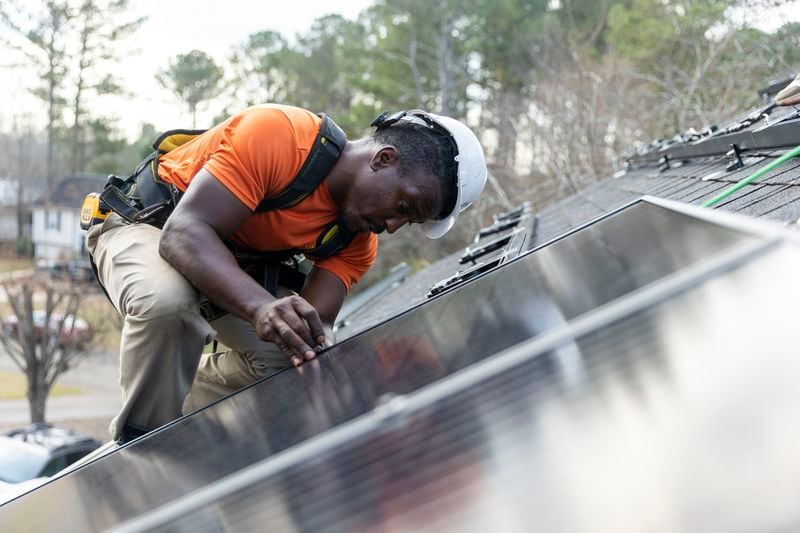 Mike Harris, an installer for Creative Solar USA, installs solar panels on a home in Ball Ground, Georgia on December 17th, 2021.