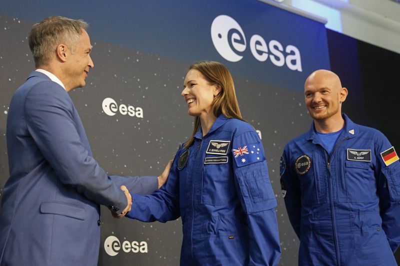 Katherine Bennell-Pegg, center, of Australia is congratulated by ESA head of robotic and human exploration Daniel Neuenschwander, left, at the candidates of the Class of 2022 graduation ceremony at the European Astronaut Centre in Cologne, Germany, Monday, April 22, 2024. ESA astronaut candidates Sophie Adenot of France, Pablo Alvarez Fernandez of Spain, Rosemary Coogan of Britain, Raphael Liegeois of Belgium and Marco Sieber of Switzerland took up duty at the European Astronaut Centre one year ago to be trained to the highest level of standards as specified by the International Space Station partners. Also concluding a year of astronaut basic training is Australian astronaut candidate Katherine Bennell-Pegg, who has trained alongside ESA's candidates. (AP Photo/Martin Meissner)