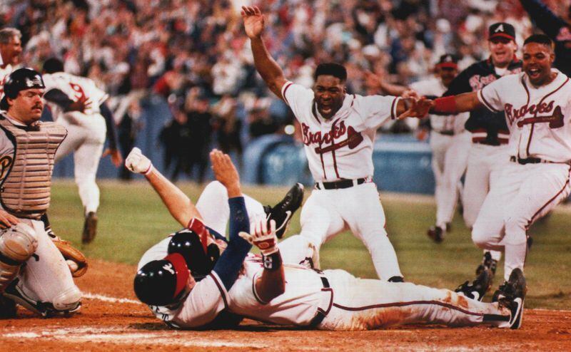 Sid Bream, prone on the ground, gets mobbed by teammates after scoring the winning run in the bottom of the 9th inning of Game 7 of the 1992 NLCS against the Pittsburgh Pirates.