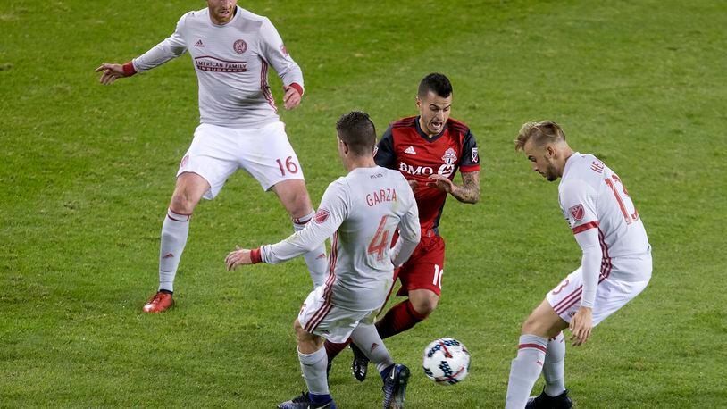 Toronto FC forward Sebastian Giovinco (10) tries to take the ball between Atlanta United’s Harrison Heath (13) and Greg Garza (4) as Chris McCann gives chase during the second half of an MLS soccer match Saturday, April 8, 2017, in Toronto. (Chris Young/The Canadian Press via AP)