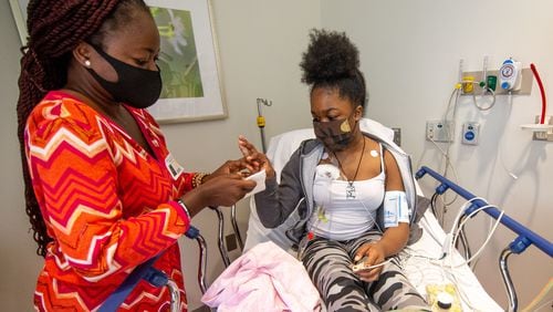 Mapillar Dahn talks with her daughter Khadeejah Tyler, 15, while she undergoes her sickle cell anemia treatment at the Scottish Rite Children's Hospital in Atlanta. STEVE SCHAEFER / SPECIAL TO THE AJC