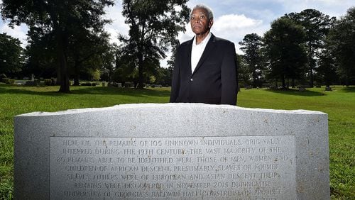 Fred Smith, co-chair of Athens Black History Bowl Committee, stands at a gravestone in Oconee Hill Cemetery in Athens where slave remains once buried on the nearby University of Georgia campus were reinterred in March 2017. Smith, a UGA alumnus, has been urging university officials since the remains were discovered in 2015 to offer a proper memorial that recognizes the slaves and their contributions to the university in its early decades. A granite memorial recognizing the individuals and other slaves is slated to be installed on the front lawn of Baldwin Hall during fall semester.