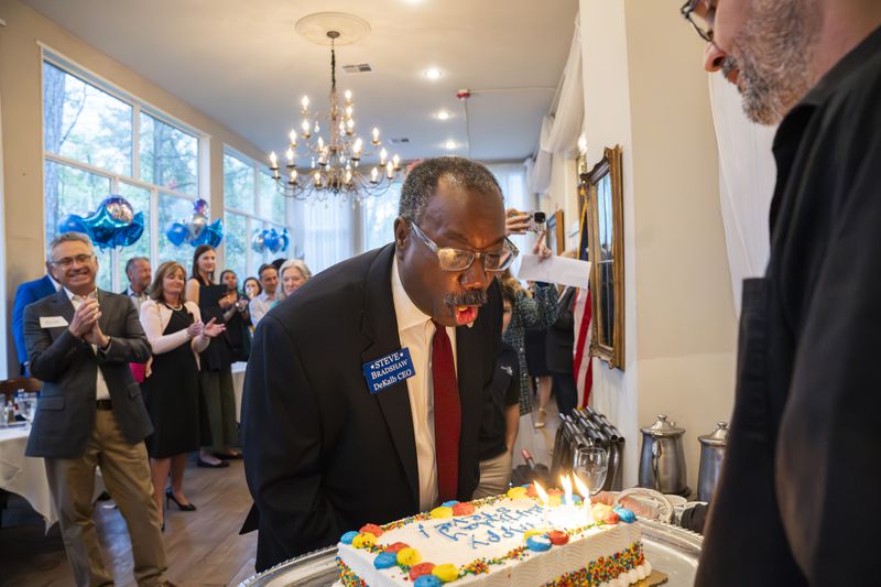 Steve Bradshaw, District 4 Commissioner, blows out birthday candles at his campaign event at Petit Violette in Atlanta, Georgia on Wednesday, April 10, 2024. (Olivia Bowdoin for the AJC).