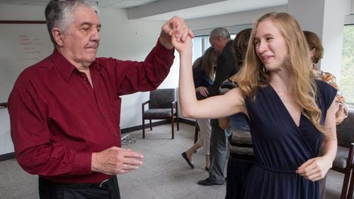 “Repeated studies have shown that adapted tango improves balance, mobility, endurance … spatial cognition and quality of life,” says Madeleine Hackney. Here, Larry Bullard twirls Ariel Hart during a dance therapy group session. (Photo by Phil Skinner)