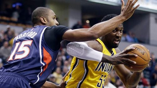 Indiana Pacers' Roy Hibbert (55) goes to the basket against Atlanta Hawks' Al Horford (15) during the first half of an NBA basketball game Monday, Dec. 8, 2014, in Indianapolis. (AP Photo/Darron Cummings)