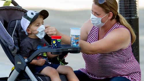 Marlie Arnold helps her son Lucas with his mask before entering the Atlanta zoo Saturday, May 16, 2020. STEVE SCHAEFER FOR THE ATLANTA JOURNAL-CONSTITUTION