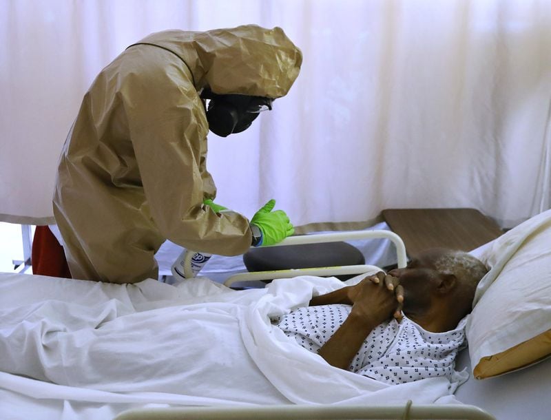 A member of the Georgia Army National Guard infection control team from the 265th Chemical Battalion gently cleans the bed railings of a resident without waking him at Legacy Transitional Care & Rehabilitation in mid-April. As of Tuesday, the Atlanta nursing home had 104 residents who tested positive for the coronavirus, and three who had died, one of the worst outbreaks among Georgia senior care facilities. The facility also had 19 staff members who had tested positive. Curtis Compton ccompton@ajc.com