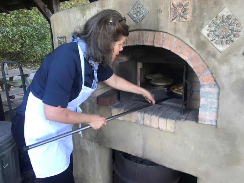 Cooking instructor Nanette Davidson demonstrates how to cook on a wood-fired oven. In 1998, Davidson developed the cooking course curriculum for the John C. Campbell Folk School in Brasstown, N.C., and remains an instructor there. She is also the author of “The Folk School Cookbook: A Collection of Seasonal Favorites From the John C. Campbell Folk School,” published this summer. LIGAYA FIGUERAS / LFIGUERAS@AJC.COM