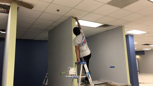 A worker paints trim at Clayton County’s renovated health department, which will reopen to the public in May after closing in February 2018 because of mold and water damage. PHOTO: LEON STAFFORD