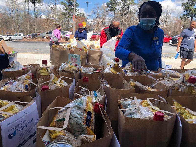 Vivian Moore, a volunteer with the East Lake Family YMCA, prepares to pass out food to visitors. The bags contained several items such as canned goods, eggs and cereal.