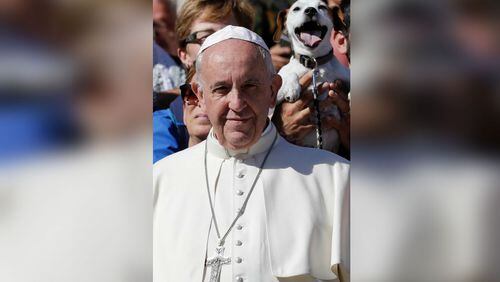 Pope Francis poses for photographers with a group of dog trainers, during his weekly general audience, in St. Peter's Square, at the Vatican, Wednesday, Oct. 5, 2016. (AP Photo/Andrew Medichini)