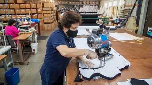 Rosa Cano, production manager at Eurotard Dancewear, cuts out the pattern for a face mask while working at the manufacturer building in Alpharetta on Sept. 3, 2020. Before the COVID-19 pandemic, Eurotard Dancewear created leotards and other dance clothing for national and international retailers. It pivoted to making personal protective equipment when Children's Healthcare of Atlanta asked for  thousands of face masks. Eurotard Dancewear also supplies medical gowns, booties and medical head caps.  (Alyssa Pointer / Alyssa.Pointer@ajc.com)