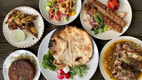 This takeout feast from Delbar in Inman Park includes (clockwise from top left): Omani prawns and heirloom salad; koobideh kebabs; lamb-neck shawarma; bread and sabzi; and sabzi polo with crispy tahdig. Wendell Brock for The Atlanta Journal-Constitution
