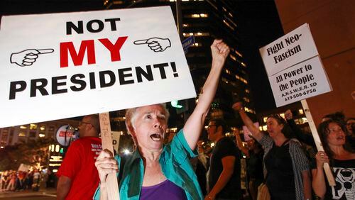 Faith Attaguile, from Encinitas, yells chants with others on the corner of Broadway and Front Street , Wednesday, Nov. 9, 2016, in downtown San Diego, during a protest in opposition of Donald Trump's presidential election victory. (Hayne Palmour IV/The San Diego Union-Tribune via AP)