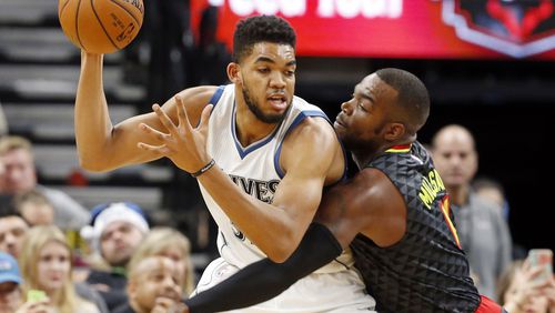 Minnesota Timberwolves’ Karl-Anthony Towns, left, keeps the ball at bay from Atlanta Hawks’ Paul Millsap during the first half of an NBA basketball game Monday, Dec. 26, 2016, in Minneapolis. (AP Photo/Jim Mone)