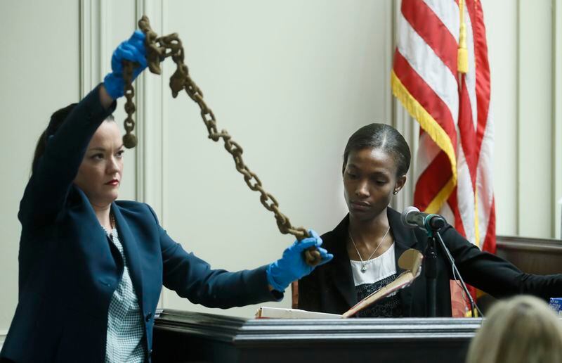As Daniellla Stuart (right), a GBI special agent and crime scene specialist, testifies about the GBI search of defendant Franklin Gebhardt’s house, Assistant District Attorney Marie Broder shows a chain recovered from the defendant's well.  