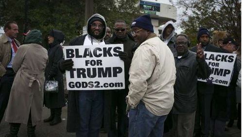 Attendees hold “Blacks For Trump” signs while waiting in line for a campaign rally with President Donald Trump in Pensacola, Fla. (Bloomberg/Nicole Craine)