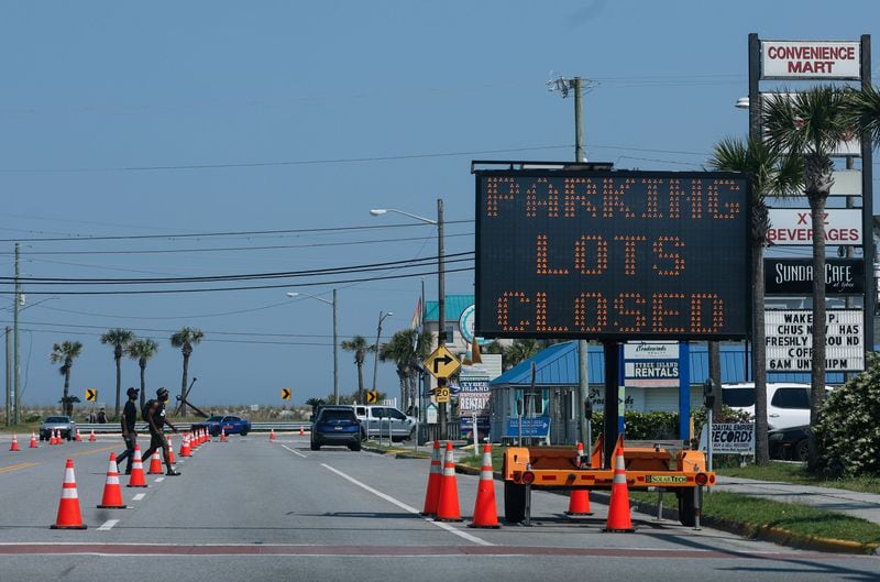A sign that reads parking lots closed on Highway 80 in Tybee Island shown on Friday, April 19, 2024. The island put various traffic protocols in place in anticipation of large crowds in town Orange Crush, an annual spring break gathering for college students. (Natrice Miller/ AJC)