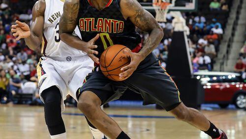 Atlanta Hawks guard Jeff Teague (0) drives to the basket in front of New Orleans Pelicans guard Norris Cole (30) during the first half of an NBA preseason basketball game in Jacksonville, Fla., Friday, Oct. 9, 2015. (AP Photo/Gary McCullough)