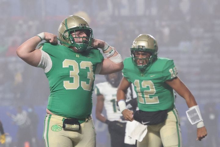 Buford fullback Nate Norys (33) celebrates after quarterback Ashton Daniels, right, scored a rushing touchdown during the third quarter against Langston Hughes in the Class 6A state title football game at Georgia State Center Parc Stadium Friday, December 10, 2021, Atlanta. JASON GETZ FOR THE ATLANTA JOURNAL-CONSTITUTION