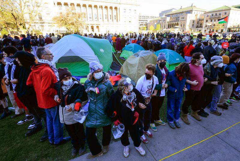 Protesters demonstrating against the war in Gaza circle a tent as law enforcement personnel prepare to remove an encampment on the campus of UW-Madison in Madison, Wis. on Wednesday, May 1, 2024. (John Hart/Wisconsin State Journal via AP)