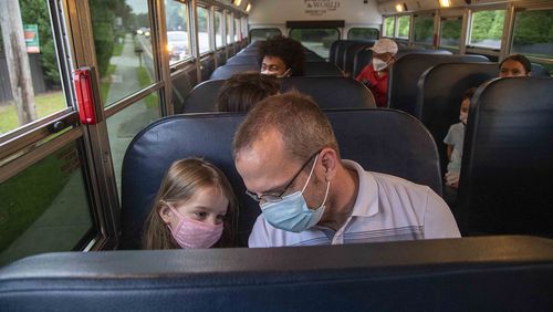 “Why aren’t there any seat belts?”, Kendall Liles, left, asked her father, T.J. Liles while riding the school bus to Kincaid Elementary School in Marietta on Friday, July 30, 2021. This was both T.J. and Kendall’s first time riding a school bus. T.J. said he wanted to give Kendall, his eldest child, some independence. “She wants to ride the bus, and we want to give her that opportunity,” he said. (Alyssa Pointer/Atlanta Journal-Constitution)