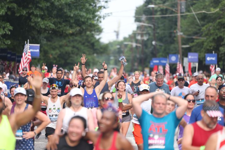 Runners cross the finish line of the 54th running of the Atlanta Journal-Constitution Peachtree Road Race in Atlanta on Tuesday, July 4, 2023.   (Jason Getz / Jason.Getz@ajc.com)