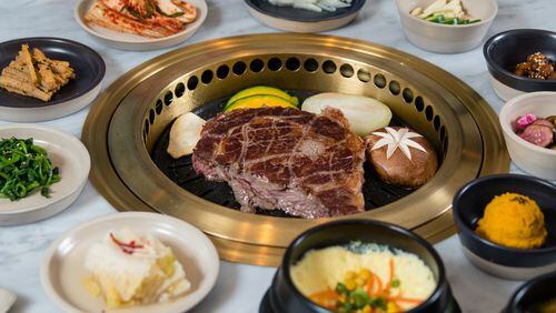 A large prime rib-eye steak cooks on the table-mounted grill at Ari Korean Steakhouse. CONTRIBUTED BY HENRI HOLLIS
