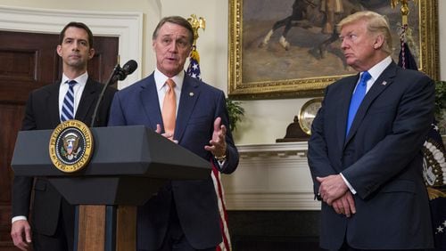 Sen. David Perdue, R-Ga., flanked by Sen. Tom Cotton, R-Ark., left, and President Donald Trump, makes an announcement on the introduction of the Reforming American Immigration for a Strong Economy (RAISE) Act in the White House on Aug. 2, 2017. (Photo by Zach Gibson - Pool/Getty Images)