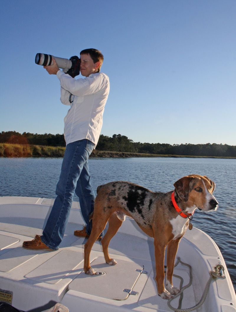 Stuckey in action taking photos on Ossabaw Island, accompanied by her faithful canine companion Blaze.  Another friend, former President Jimmy Carter, wrote the foreword for the new book "Ossabaw Island: A Sense of Place," in which some 105 of Stuckey's photos appear. Photo by Matthew Page