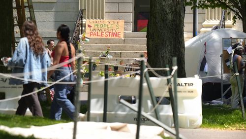 People walk past the remnants of an encampment of tents in Harvard Yard on the campus of Harvard University, Tuesday, May 14, 2024, in Cambridge, Mass. Anti-war protesters have taken down their tents in Harvard Yard after the university agreed to meet to discuss their demands. The student protest group calling themselves Harvard Out of Occupied Palestine say their camp "outlasted its utility." (AP Photo/Steven Senne)