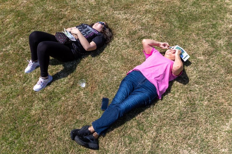 (L-R) Karla Morales, a student, and Maria Barreto watch the solar eclipse at Georgia Gwinnett College in Lawrenceville on Monday, April 8, 2024. (Arvin Temkar / arvin.temkar@ajc.com)