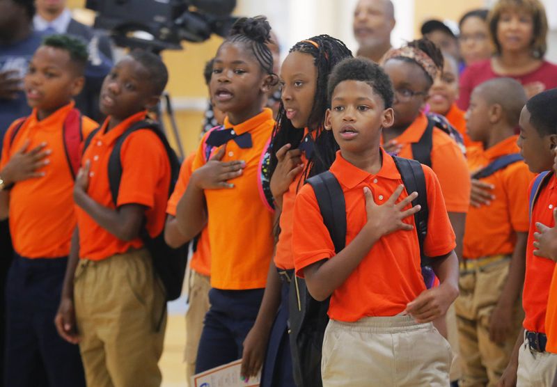 Students stand for the Pledge of Allegiance as the first day of school starts with a program in the gymnasium. Congressman John Lewis was on hand, along with Atlanta Public Schools Superintendent Meria Carstarphen for the first day of school at the new John Lewis Invictus Academy. BOB ANDRES /BANDRES@AJC.COM