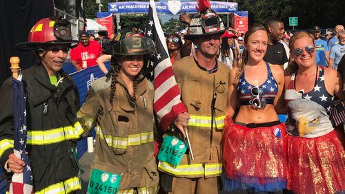 Participating firefighters take a photo after finishing the AJC Peachtree Road Race on Wednesday, July 4, 2018. (Photo by Zachary Hansen/AJC)