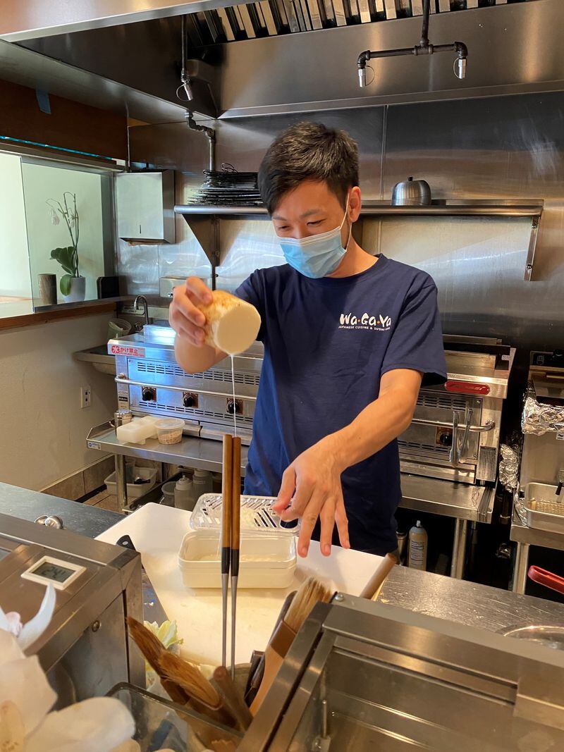 Takashi Otsuka grates Japanese yam to add to okonomiyaki batter at Chirori, one of his Japanese restaurants on 14th Street. Wendell Brock/For The AJC