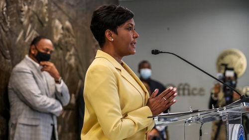 May 7, 2021 Atlanta:  Atlanta Mayor Keisha Lance-Bottoms held a press conference Friday, May 7, 2021 at Atlanta City Hall speaking about her decision not to run for a second term as her husband Derek (left) looks on. In her first public appearance since announcing her decision to supporters Thursday night, Bottoms said her decision was guided by faith. “In the same way that it was very clear to me almost five years ago that I should run for mayor of Atlanta, it is abundantly clear to me today that it is time to pass the baton on to someone else,” Bottoms said at an emotional news conference at City Hall. She added that “the last three years have not been at all what I would have scripted for our city,” referencing a crippling cyber attack, a widening federal corruption investigation into the previous administration, the COVID-19 pandemic and civil unrest last year. Bottoms said she doesn’t know what’s next for her; she denied rumors that she or her husband Derek have taken jobs for Walgreens out of state. “I can’t get Derek to move two miles off Cascade Road,” she said. Bottoms, who was seen as a strong incumbent candidate despite a spike in violent crime, told friends and supporters Thursday evening she won’t seek a second term. She released a video and statement online a few hours later elaborating on her decision and reflecting on her time in office. “This is not something I woke up and decided yesterday,” Bottoms said Friday. “This is something I’ve been thinking about for a very long time.” (John Spink / John.Spink@ajc.com)